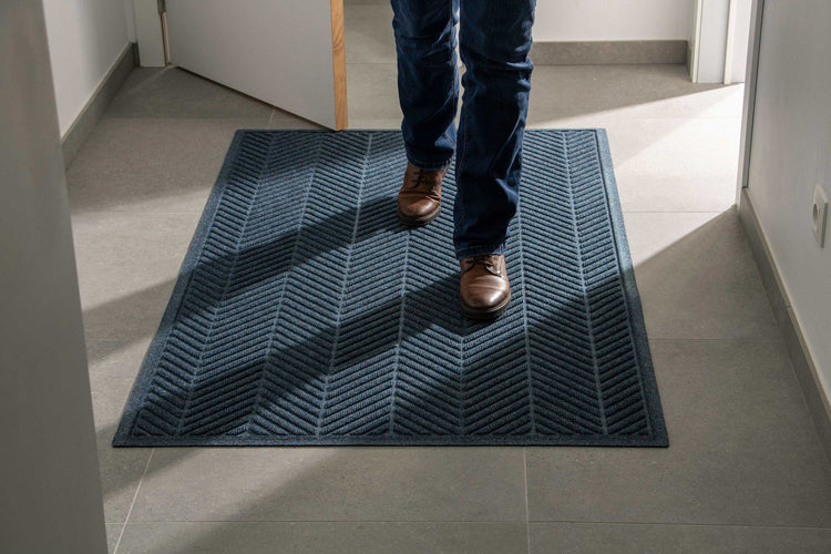 Navy WaterHog Herringbone entrance mat with fabric border in a commercial corridor