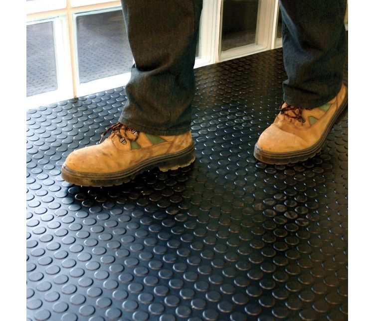 Black Dot rubber matting runner on a light floor with a person walking along it in dark trousers and shoes